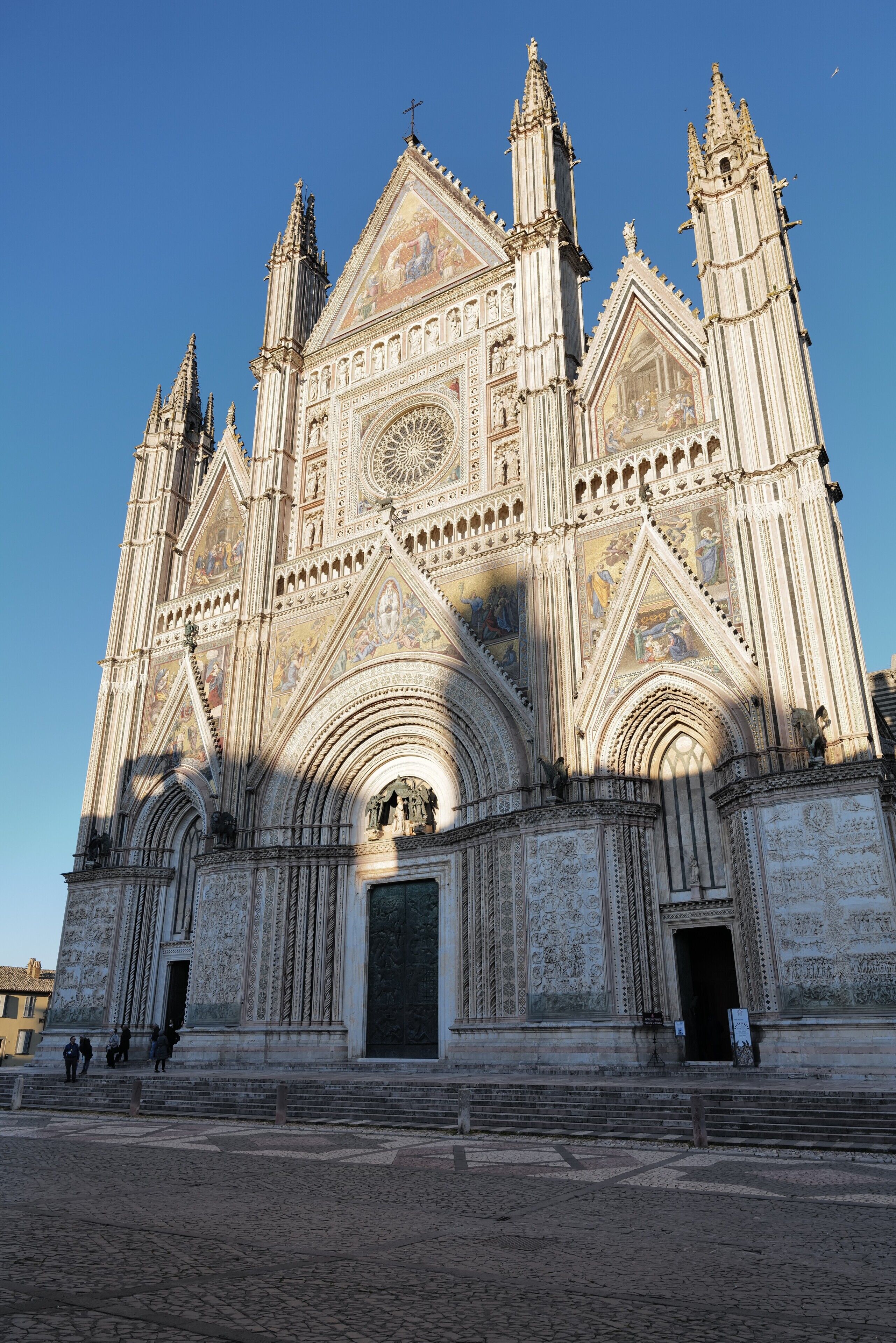 Une vaste cathédrale aux détails architecturaux complexes, dotée d’une imposante rosace et d’une grande entrée.