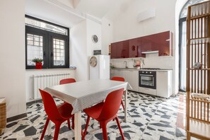 Cocina compacta con comedor, refrigerador, horno y ventana con vistas.