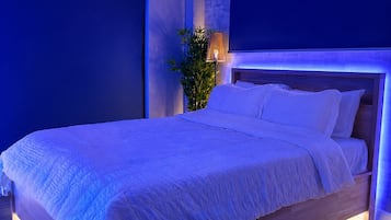 Ein modernes Schlafzimmer mit einem großen Bett, einer Wand-Klimaanlage und einer Topfpflanze.