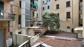 Un patio con un árbol, una escalera de metal y una cubierta de madera.