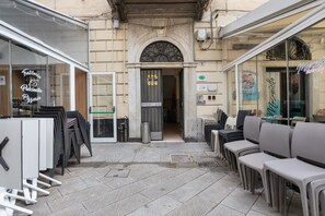 An outdoor seating area with tables and chairs, a pizzeria sign, and a storefront with a sign that reads 'Mazzarino Entrance.' - Apartment 'Matt House' with Wi-Fi and Air Conditioning (La Spezia)