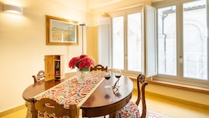 A dining table with a patterned tablecloth, a wine bottle, and two wine glasses. - Apartment 'La Chiocciola Nel Labirinto' with Balcony, Wi-Fi and Air Conditioning (Lucca)