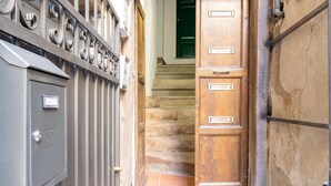 A wooden door with a metal gate and a metal utility box. - Apartment 'La Chiocciola Nel Labirinto' with Balcony, Wi-Fi and Air Conditioning (Lucca)