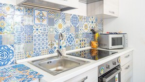 Una cocina con lavamanos, microondas y horno.