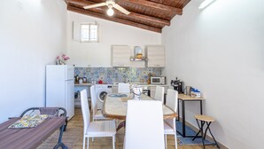 Cocina compacta con comedor, ventilador de techo, lavadora y microondas.