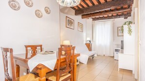 Un comedor con una mesa y sillas de madera, un mantel blanco y un ventilador de techo.