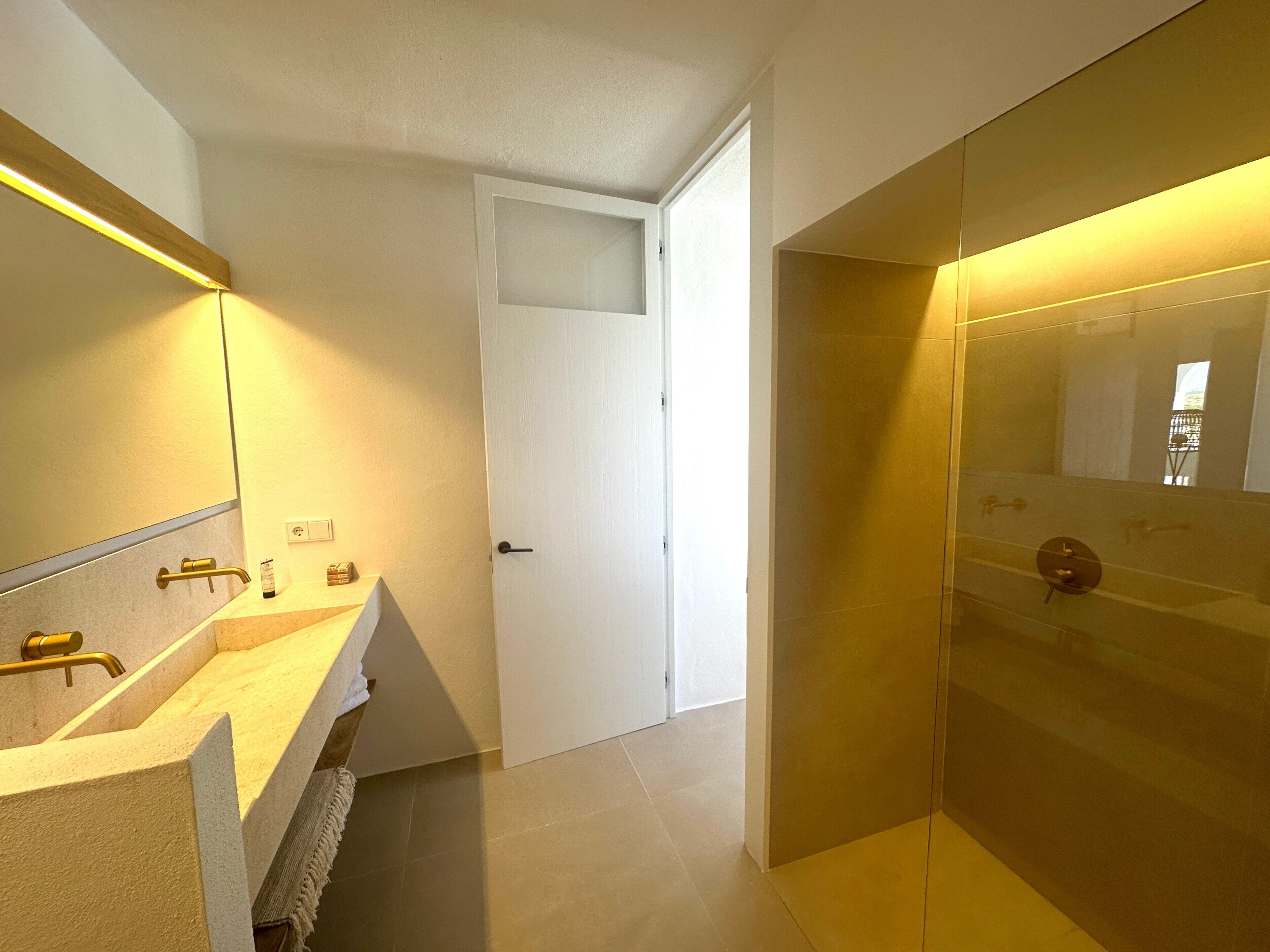 Une salle de bain moderne avec un meuble-lavabo, une douche et un miroir.