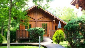 Eine Holzhütte mit Veranda, einem Weg zum Eingang und einem kleinen Garten.