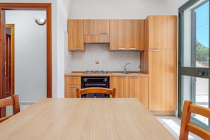 A kitchen with wooden cabinets, a built-in oven, and a window.