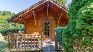 A wooden cabin with a porch, a door, and a small window. - Apartment 'Chalet Violette' with Mountain View, Wi-Fi and Air Conditioning (Vaulnaveys-le-Bas)