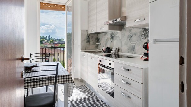 Une cuisine moderne avec un coin repas, une vue par la fenêtre et un balcon.