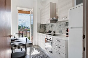 Una cucina moderna con zona pranzo, vista dalla finestra e balcone.