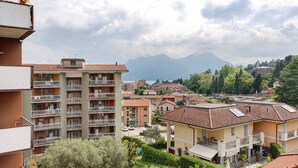 Un quartier résidentiel avec des immeubles à plusieurs étages, des balcons et une montagne en arrière-plan.