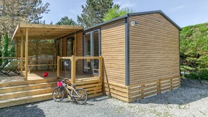 Eine Holzhütte mit Veranda, einem Fahrrad und einem Fußball.
