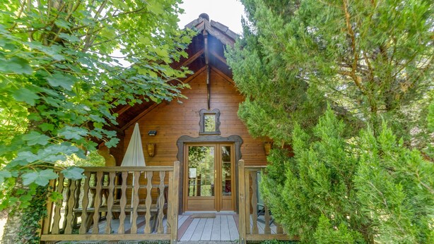 A wooden cabin with a porch, stone steps, and a door with a small window above it. - Apartment 'Narcisse' with Mountain View, Wi-Fi and Air Conditioning (Vaulnaveys-le-Bas)