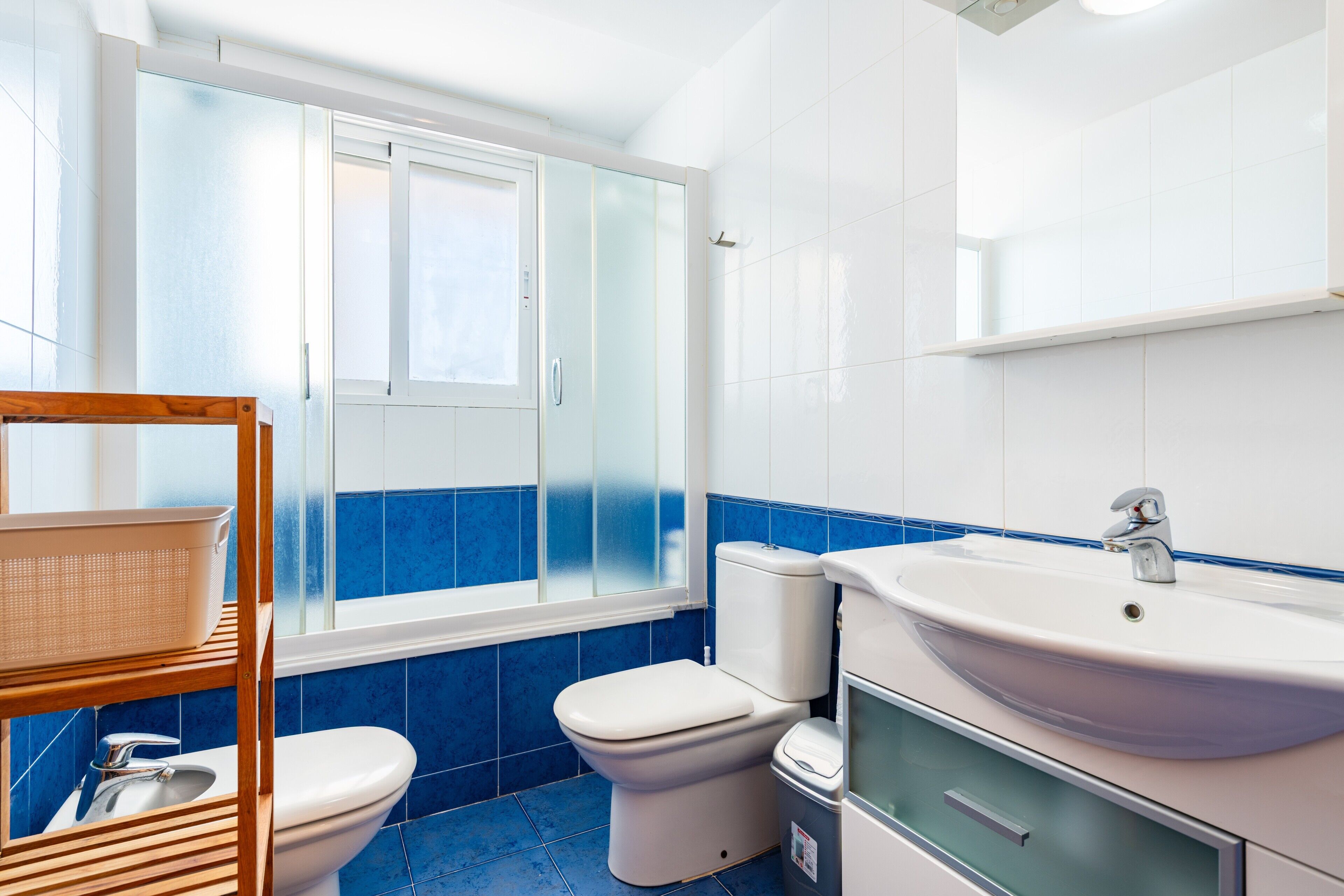 Une salle de bain avec des toilettes, un lavabo et une fenêtre.