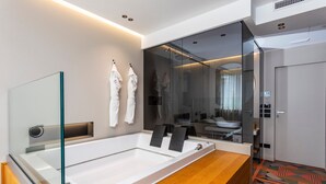 Ein modernes Badezimmer mit einer großen Badewanne, einer Duschkabine aus Glas und einem Holzbadezimmer-Möbel.