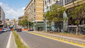 Eine Straße mit Gebäuden, einem klaren Himmel und einer gelben Fahrbahnmarkierung.