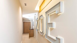 A modern hallway with recessed lighting, a wooden door, and a minimalist design. - Bed and Breakfast 'Zoe Luxury Suites - Deluxe 03' with Sea View, Wi-Fi and Air Conditioning (Catania)
