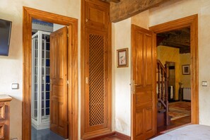 A room with wooden doors, a visible staircase, and a radiator.