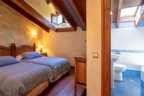A bedroom with two beds, a wooden headboard, a nightstand, a wall-mounted lamp, and a skylight. - Room 'Araucaria' with Mountain View, Shared Garden and Wi-Fi (Con)