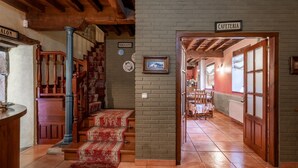 En hotellobby med en trappa, en skylt som visar vägen till kafeterian och ett matområde i bakgrunden.