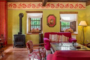 Une pièce avec une cheminée, un canapé, un fauteuil et une table.