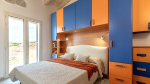 Un dormitorio con cama, armario y ventana con vistas.