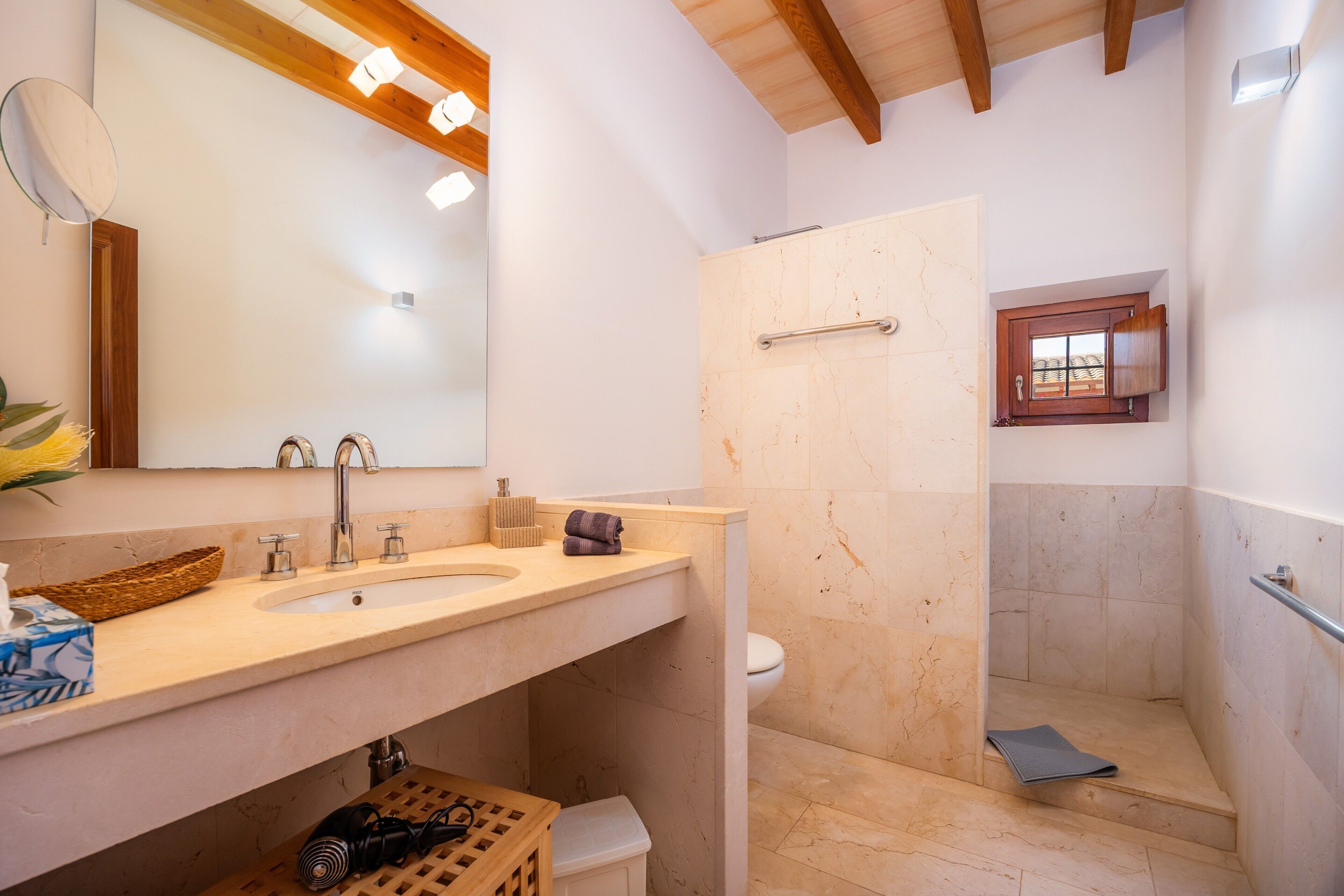 A bathroom with a sink, mirror, and shower.
