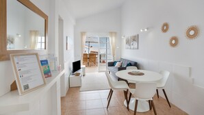 A modern interior with a dining area, a sofa, and a TV.