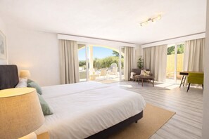 A hotel room with a large bed, a desk, and a view of the outdoors.