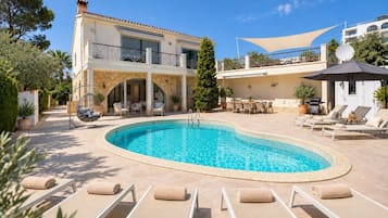 Un espace aménagé au bord de la piscine, avec des chaises longues et une piscine.