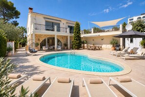 A poolside area with lounge chairs and a swimming pool.