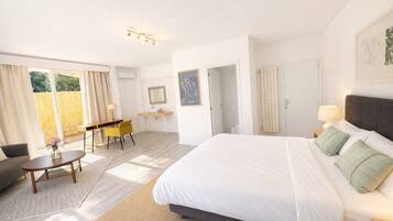 Une chambre d’hôtel avec un grand lit, un bureau, une chaise et une vue sur l’extérieur.