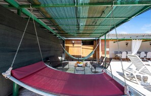Relax in an outdoor space with a hammock, chairs, and table.
