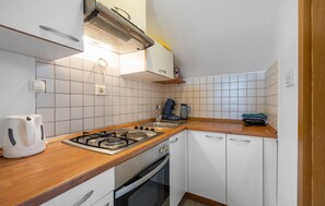 Equipped with a gas stove, oven, and stainless steel sink, this kitchen offers a convenient space for meal preparation.