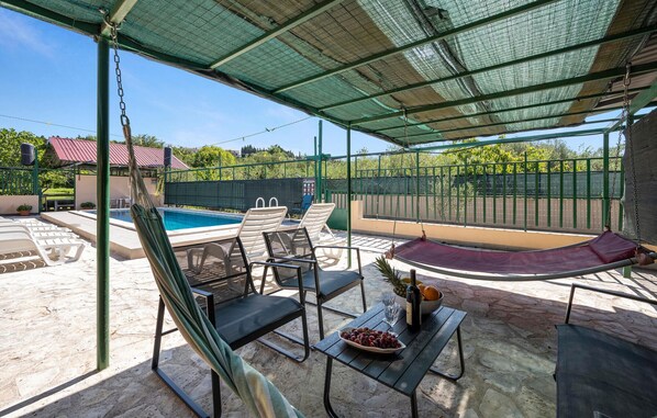 Relax by the pool with a refreshing drink and a view of the surrounding landscape.