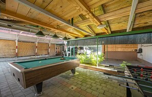 Relax and play in this vibrant indoor space featuring a pool table, foosball table, and cozy seating area.