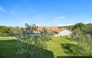 Escape to a serene countryside retreat surrounded by lush greenery and olive trees.