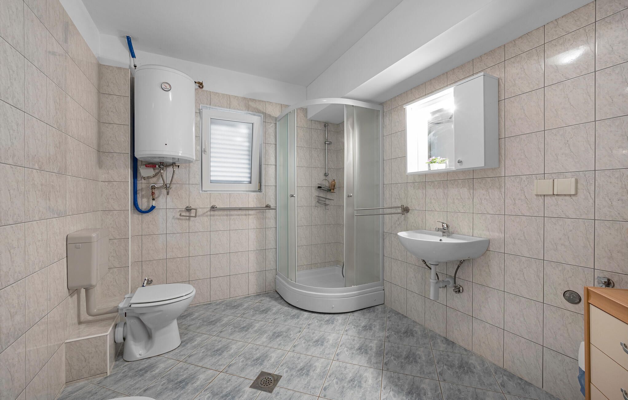 Une salle de bain moderne équipée de toilettes, d’une douche et d’un lavabo.