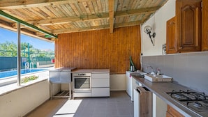 A compact kitchen with wooden walls, a gas stove, and a small sink.