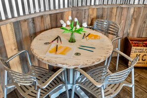 A round table with a rustic finish, surrounded by metal chairs with perforated backs. - Southwest Silo Stay- 1 Bedroom Near Zion & Bryce (Fredonia)