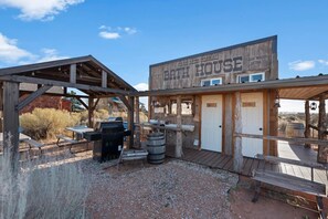 A rustic outdoor setting with a wooden structure labeled 'Cane Beds Corrals' and 'Both House.' It includes a barbecue grill, a sink, and a wooden bench. - Southwest Silo Stay- 1 Bedroom Near Zion & Bryce (Fredonia)
