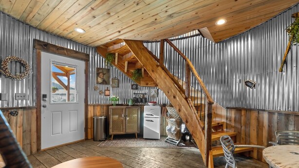 A rustic interior with a wooden staircase, a kitchen area, and a dining space. - Southwest Silo Stay- 1 Bedroom Near Zion & Bryce (Fredonia)