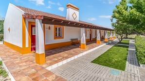 Un edificio con techo de tejas, una puerta roja y un pequeño porche.