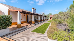 A hotel with a long corridor, individual rooms, and a small garden area. - Apartment 'Casa Ti Herminia - Suite Deluxe' with Shared Pool, Wi-Fi and Air Conditioning (Carvalhal)