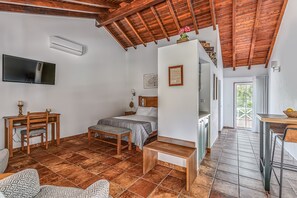 Un dormitorio con cama, mesita de noche y escritorio con sillas.