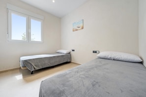 A bedroom with two beds, a window, and a wall-mounted picture. - Holiday Home 'Illa De Buda' with Mountain View, Wi-Fi and Air Conditioning (Camarles)