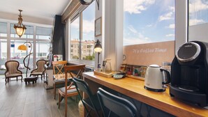 A cozy room with a wooden bar, chairs, a chessboard, and a coffee machine. - Room 'Duplo Superior' with Balcony, Wi-Fi and Air Conditioning (São Brás de Alportel)