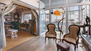 A spacious room with large windows, a wooden floor, and two upholstered chairs. - Room 'Duplo Superior' with Balcony, Wi-Fi and Air Conditioning (São Brás de Alportel)